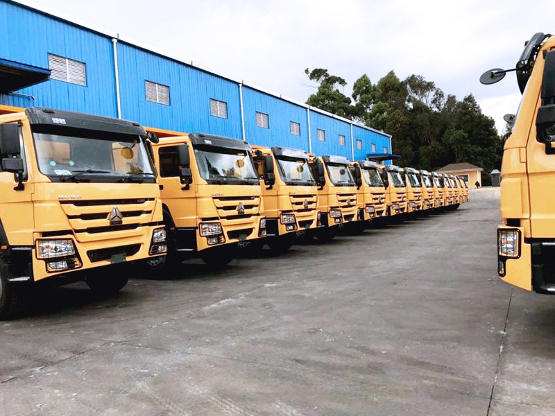 HOWO-7自卸车肯尼亚交付现场，车辆整齐排列，等待交付，投入肯尼亚的工程建设